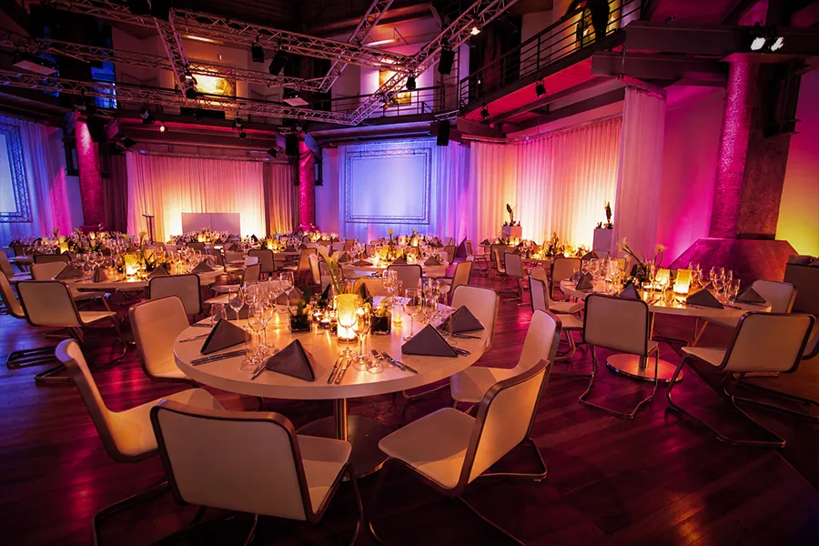 Modernes Gala Dinner im OKTOGON auf Zollverein in Essen mit festlich gedeckten Rundtischen, Designerstühlen und atmosphärischer Beleuchtung