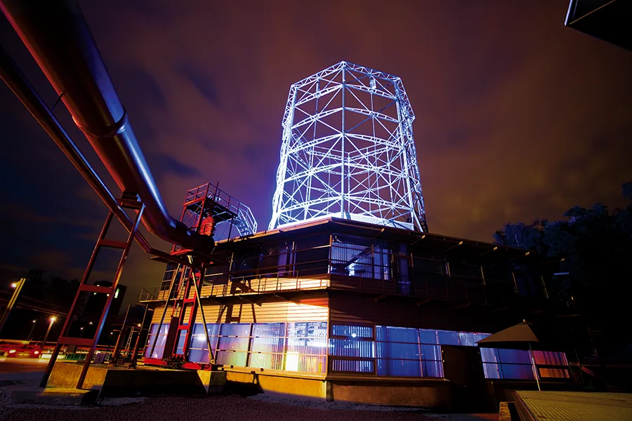 Außenansicht des OKTOGON auf Zollverein bei Nacht mit beleuchtetem Kühlturm