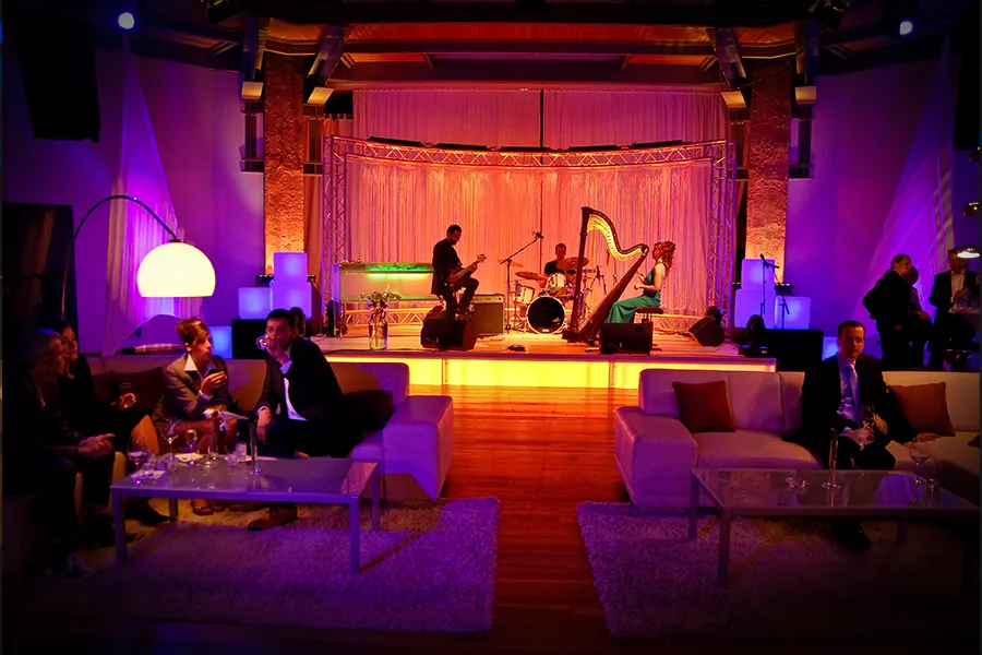Liveband mit Harfe und Schlagzeug bei einem Get-together im OKTOGON auf Zollverein in Essen, mit weißen Lounge-Sitzgruppen und Gästen im Vordergrund